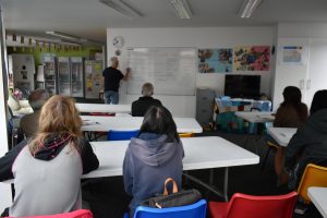 English class, pupils and teacher writing on whiteboard